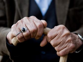 Elderly man holds cane
