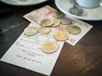 A bill with payment in Euros on the table of a cafe.
